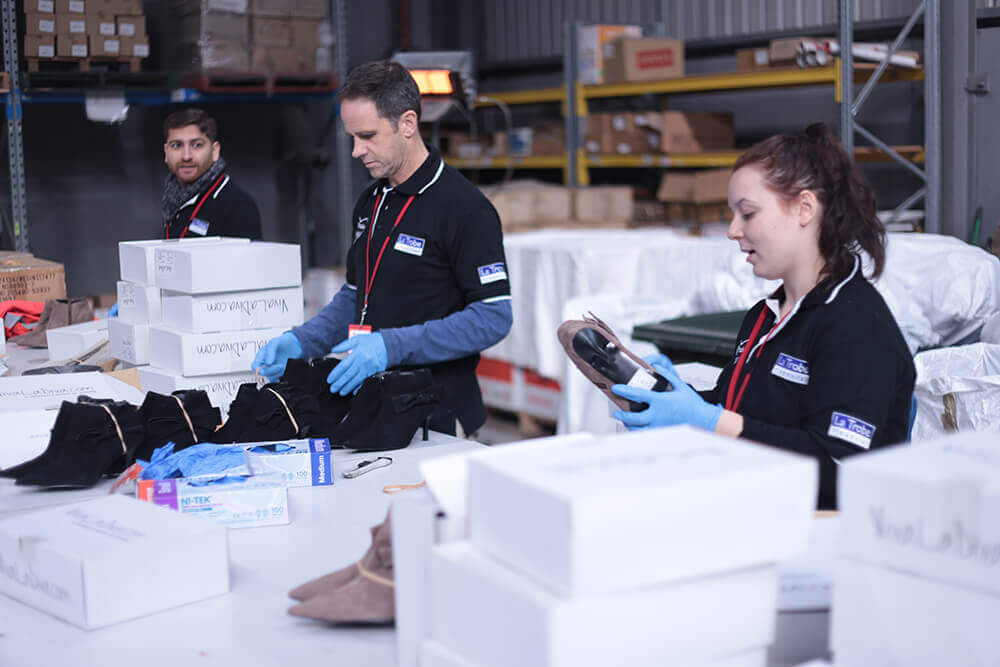 La Trobe Financial staff volunteering sorting shoes in warehouse